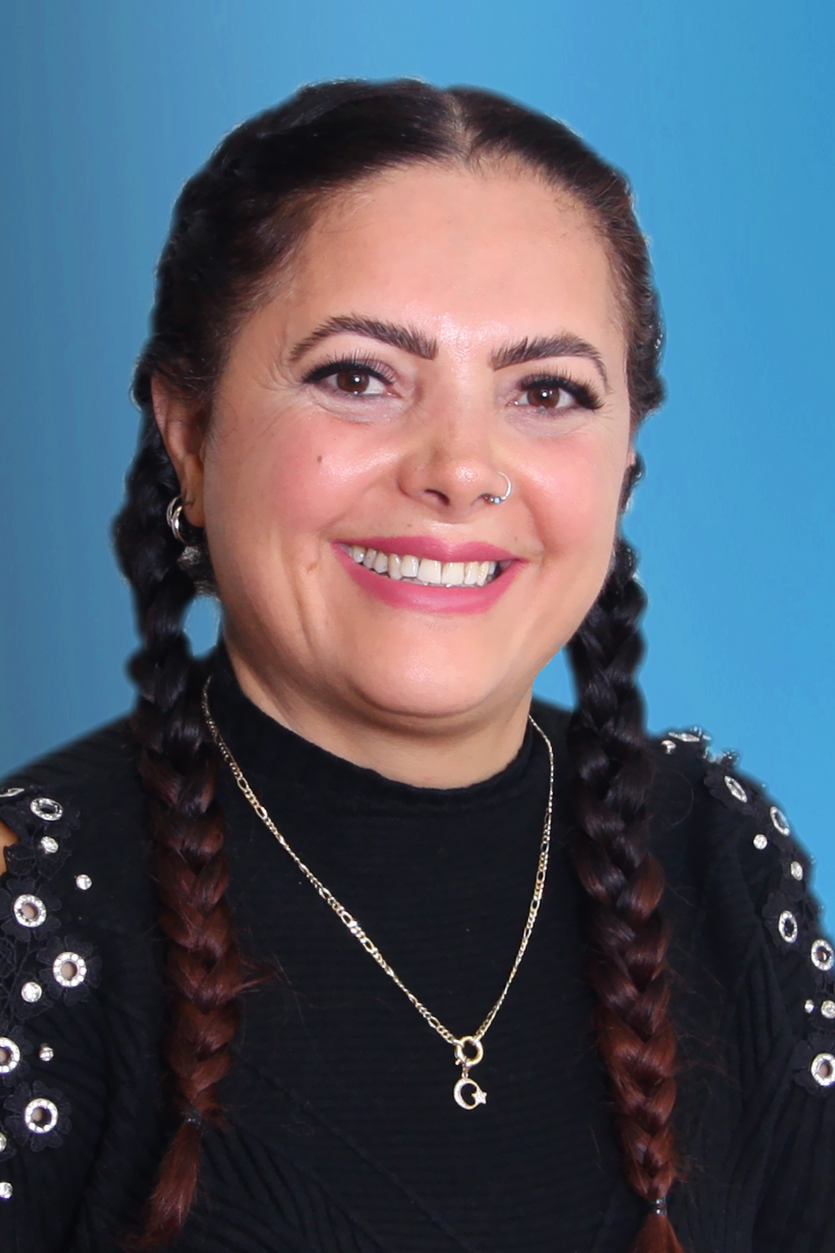 Foto von einer Mitarbetrein von KARAWANE vor einem blauen Hintergrund